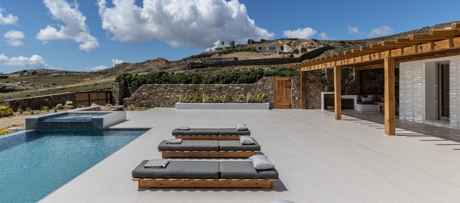 Exterior pool area with sun loungers of Villa Golden Elena in Mykonos